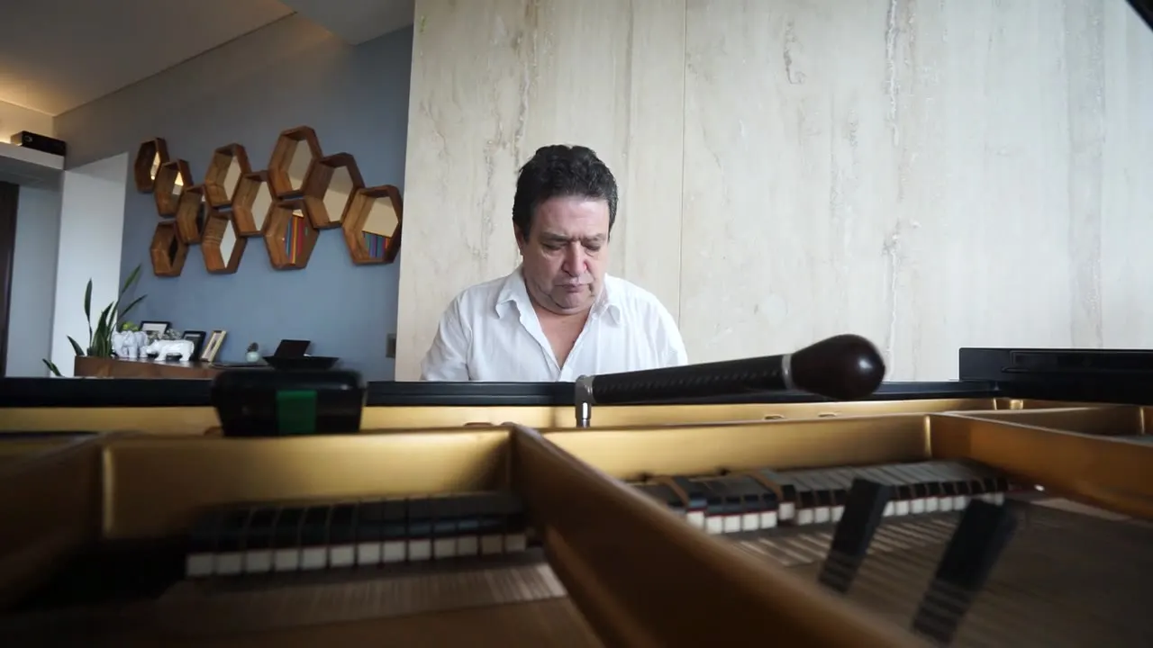 El maestro Rafael Melo afina un piano de cola, visto desde dentro del instrumento.